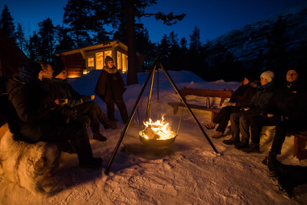 En gruppe samlet rundt bålet en vinterkveld